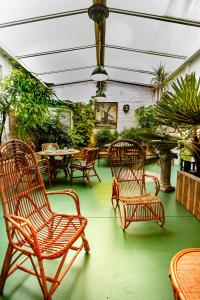 a patio with chairs and tables and plants at JARDIN D'HIVER CASSEL Suite de 70 m2 in Cassel