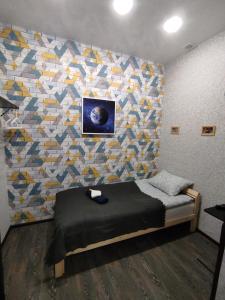 a bedroom with a bed with a colorful wall at ОТЕЛЬ СОН lite in Yekaterinburg