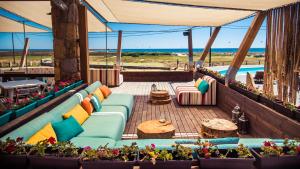 a patio with blue couches and tables and flowers at Keros Blue - Luxury in Wilderness in Kalliópi
