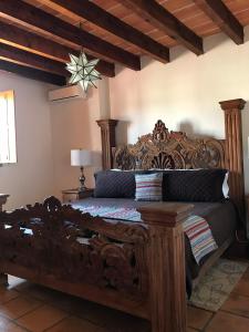 Schlafzimmer mit einem Holzbett mit einem Kopfteil aus Holz in der Unterkunft Hotel Casa Oratorio "Adults Only" in San Miguel de Allende