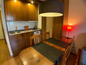 una pequeña cocina con mesa de madera y fregadero en Apartamentos Los Lagos, en Benasque