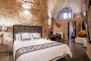 ein Schlafzimmer mit einem großen Bett in einer Ziegelwand in der Unterkunft 19.52 Matera in Matera