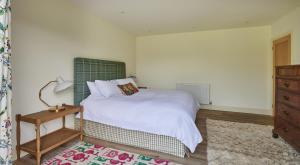a bedroom with a white bed and a nightstand and a bed sidx sidx sidx at The Cabin in Haverfordwest +11 photos