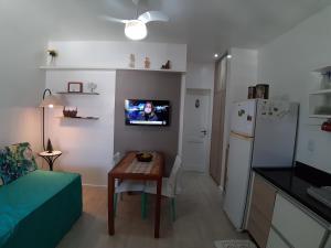 a small living room with a table and a refrigerator at Residencial Privilegio in Florianópolis