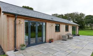 Casa con puertas de cristal y patio en The Cabin en Haverfordwest