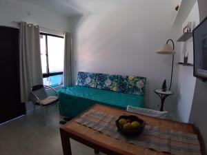 a living room with a green couch and a table at Residencial Privilegio in Florianópolis