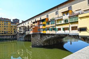 un viejo puente sobre un río con edificios en Nonna Lina Rooms, en Florencia