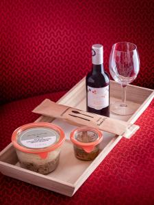 ein Tablett mit einer Flasche Wein und einem Glas in der Unterkunft Hôtel Charlemagne by Happyculture in Lyon