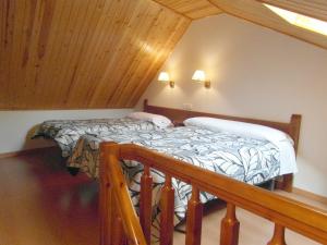 two beds in a room with a wooden ceiling at Apartamentos Los Lagos in Benasque
