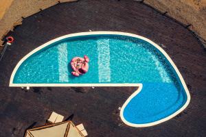 a person is laying in a swimming pool at Keros Blue - Luxury in Wilderness in Kalliópi