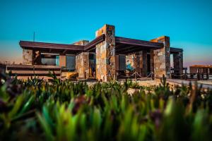 a house in the desert with grass in the foreground at Keros Blue - Luxury in Wilderness in Kalliópi