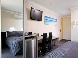a hotel room with a television and a bed at Dolphin Shores in Vincentia