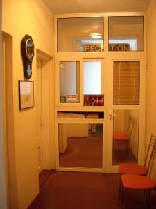 a room with a glass door with a red chair at Guesthouse Tzar Asen in Sofia