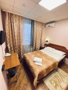 - une chambre avec un lit, une table et une fenêtre dans l'établissement Hotel na Okskoy, à Moscou