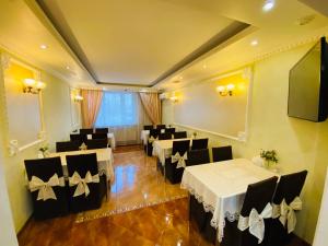 une salle de banquet avec des tables blanches et des chaises noires dans l'établissement Hotel na Okskoy, à Moscou
