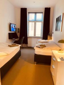 Camera con 2 letti, scrivania e finestra. di Davaa's Bed & Breakfast a Randers