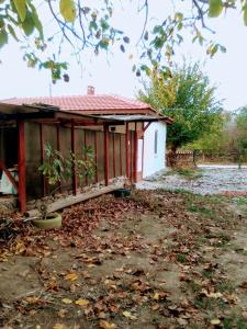 a small house with a red roof with leaves on the ground at Granichar 2 Boards in Granichar