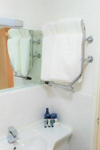 a bathroom sink with a mirror and a towel at The Dwelling Point - Cannon Street in London