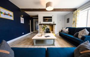 a living room with a blue couch and a table at Farmcourt Barn 55 Eastfield Lane in Lincoln