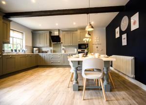 a kitchen with a table and chairs in a room at Farmcourt Barn 55 Eastfield Lane in Lincoln