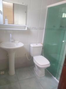 a bathroom with a toilet and a sink and a shower at Casadateca in Praia Vermelha