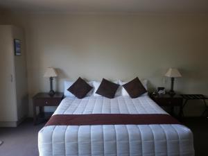 a bedroom with a large white bed with pillows at Executive On Fenton in Rotorua