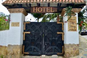 una puerta negra con un cartel que diga hotel en Hotel Casona del Virrey, en Moniquirá