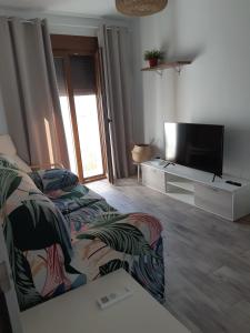 ein Wohnzimmer mit einem Bett und einem Flachbild-TV in der Unterkunft Casa Quimeres in Denia