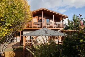 a wooden house with a deck and a porch at El Refugi de les Basses in Campelles
