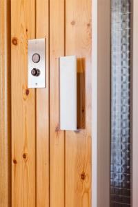 a lightswitch on a wooden wall next to a mirror at El Refugi de les Basses in Campelles