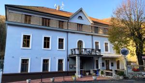 un grande edificio bianco con balcone di Hotel Sýkora a Křivoklát