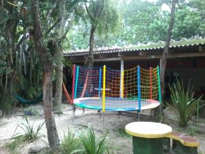 un colorido parque infantil frente a una casa en Pousada Fazendinha Tatuira en Imbé
