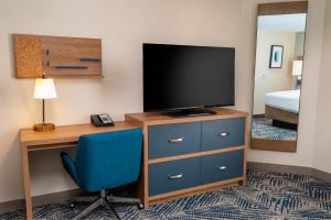 a room with a desk with a television and a blue chair at Candlewood Suites - Las Vegas - E Tropicana, an IHG Hotel in Las Vegas