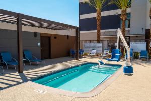 einem Pool mit Stühlen und einer Rutsche vor einem Gebäude in der Unterkunft Candlewood Suites - Las Vegas - E Tropicana, an IHG Hotel in Las Vegas