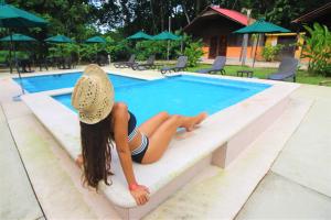 a woman in a bikini sitting on top of a swimming pool at Cabañas Kin Balam Palenque in Palenque