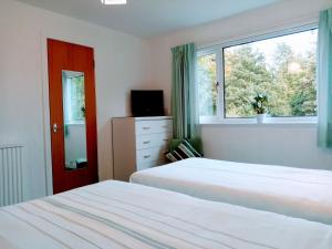 una camera con due letti e una finestra di The Laurels Guest House a Blairgowrie