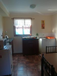 uma cozinha com um lavatório, um frigorífico e uma janela em Cabañas Tu Bosque em Isla Negra