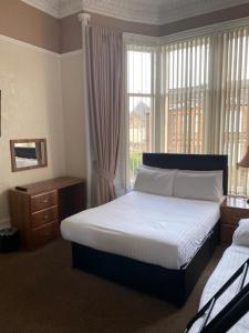 um quarto com uma cama grande e uma janela em Onslow bed and breakfast em Glasgow