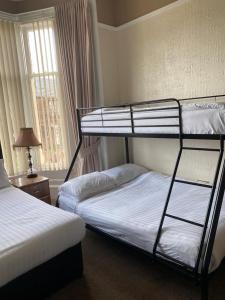 two bunk beds in a room with a window at Onslow bed and breakfast in Glasgow