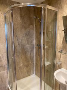 a shower with a glass door next to a sink at Onslow bed and breakfast in Glasgow