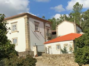 Cette grande maison blanche est dotée d'un mur en pierre. dans l'établissement Quinta do Bravio, à Barroselas