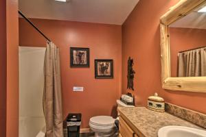 a bathroom with a toilet and a sink and a mirror at Expansive Ruth Lake Home with Dock, Fire Pit and Beach in Emily +37 photos