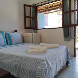 a white bed with towels on top of it at Pousada Céu Azul in Sao Jorge