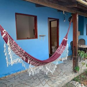 a blue house with a hammock in front of it at Pousada Céu Azul in Sao Jorge +28 photos