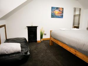 a bedroom with a large bed and a fireplace at The Stone House in Nottingham