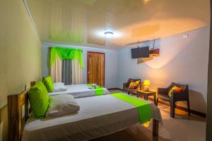 ein Schlafzimmer mit 2 Betten und ein Wohnzimmer in der Unterkunft Rio Celeste Springs Blue Lodge in Bijagua