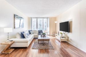 a living room with a white couch and a tv at Sunny Isles Ocean Reserve Condo Apartments in Miami Beach