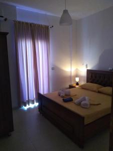 - une chambre avec un grand lit et des serviettes dans l'établissement Vila Pasqyra, à Ksamil
