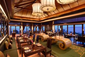 een restaurant met tafels en stoelen en klokken aan het plafond bij Banyan Tree Lang Co in Lang Co