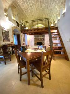 ein Esszimmer mit einem Holztisch und Stühlen in der Unterkunft San Domenico Suite in Martano
